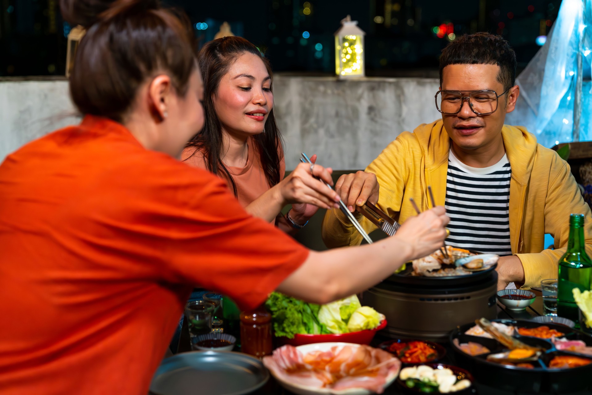 Group of Asian people having dinner party together at outdoor rooftop.
