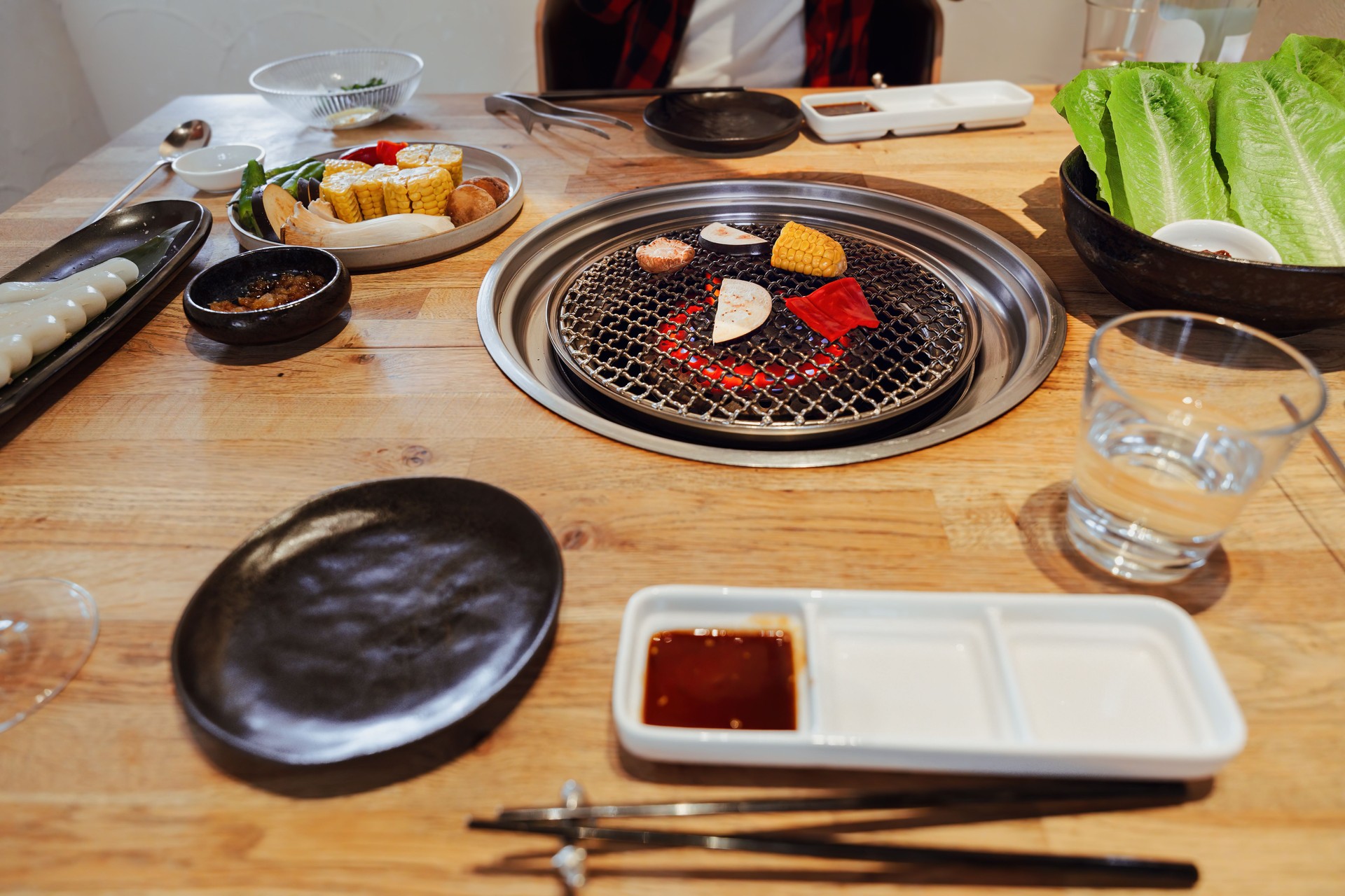 Yakiniku Grill with Vegetables and Side Dishes on Korean BBQ Table