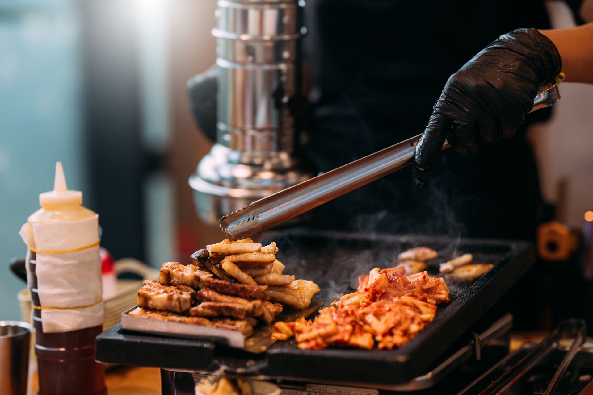 Sizzling Sensation: Traditional Korean BBQ Delights from the Chef's Stove

A chef grilling pork meat on the stove to serve in a restaurant. Traditional Korean BBQ style cuisine.